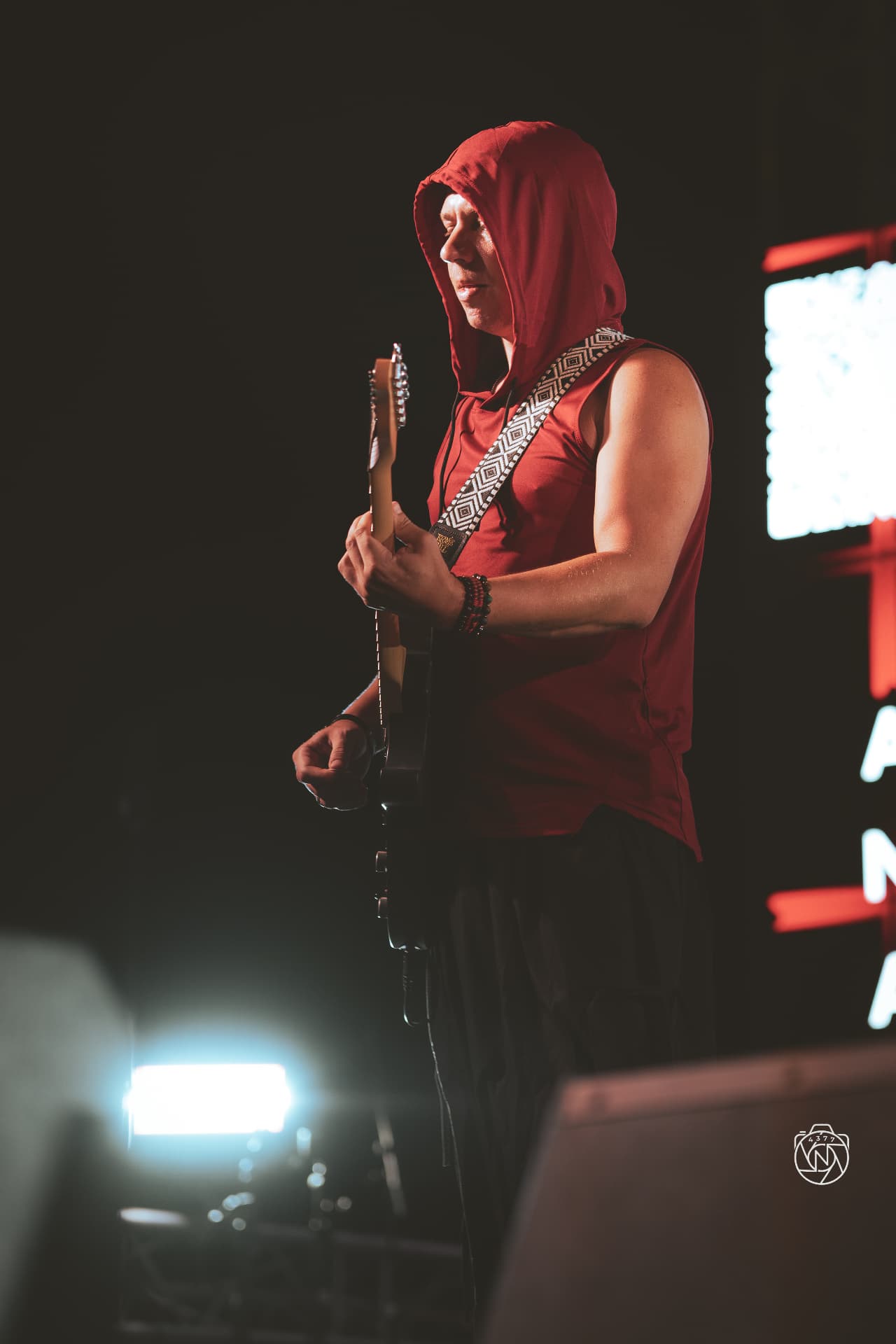 ANAEVE guitarist performing live in a red hooded top