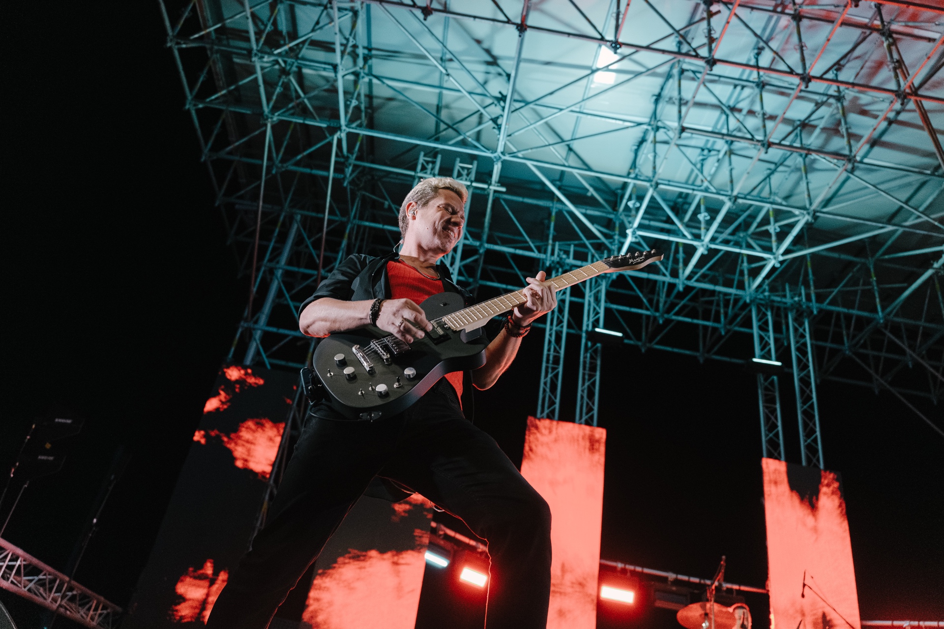 ANAEVE guitarist shot from below against stage rigging