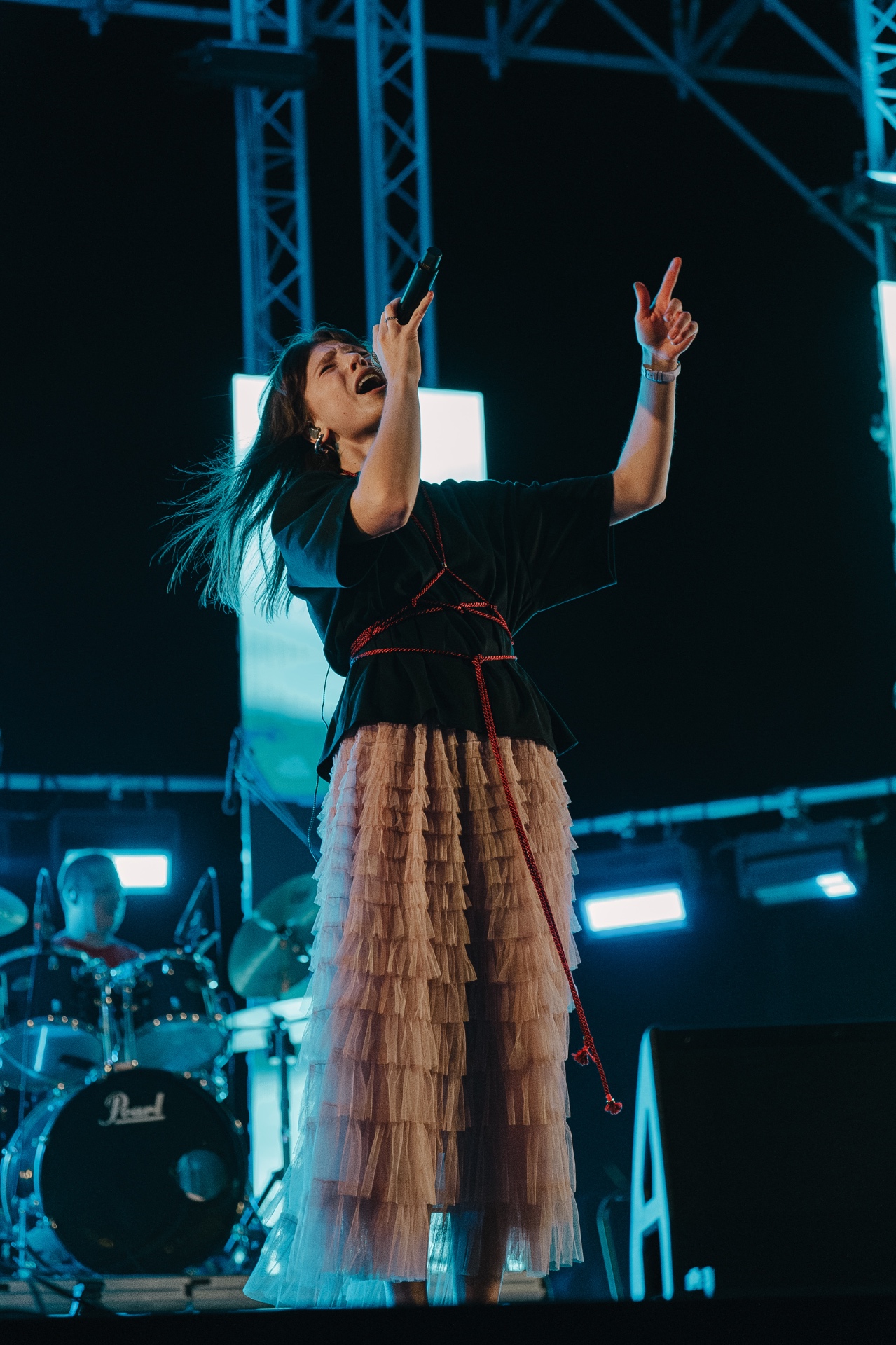 ANAEVE vocalist mid-performance, arms raised
